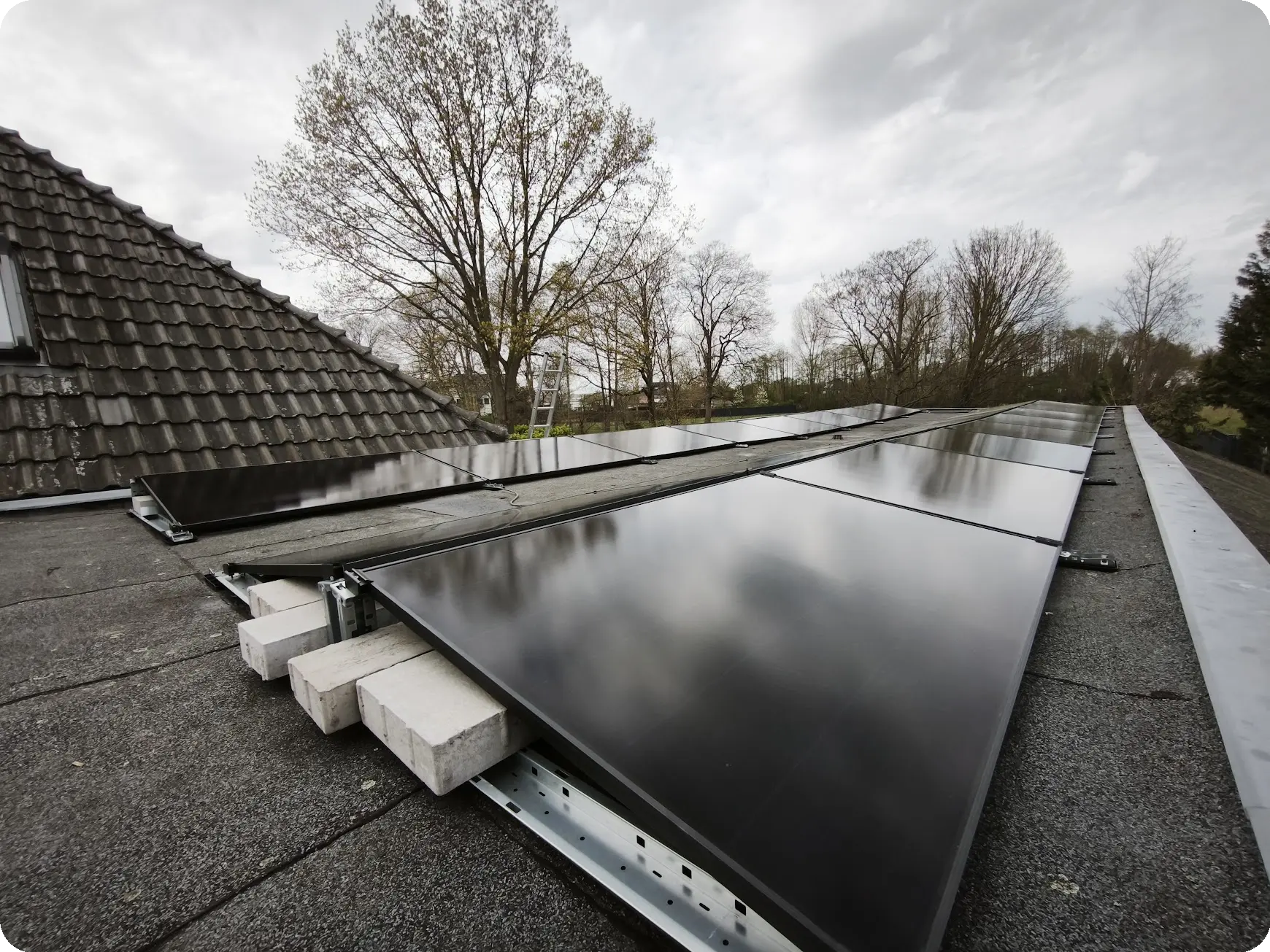 PV-Anlage auf einer gro&szlig;en Garage mit Flachdach. Flach aufgest&auml;nderte Photovoltaik-Anlage mit Ost-West-Ausrichtung f&uuml;r gleichm&auml;&szlig;ige Erzeugungsleistung &uuml;ber den Tag und sehr gute Leistung auch bei diffuser Sonneneinstrahlung bei bew&ouml;lktem Himmer