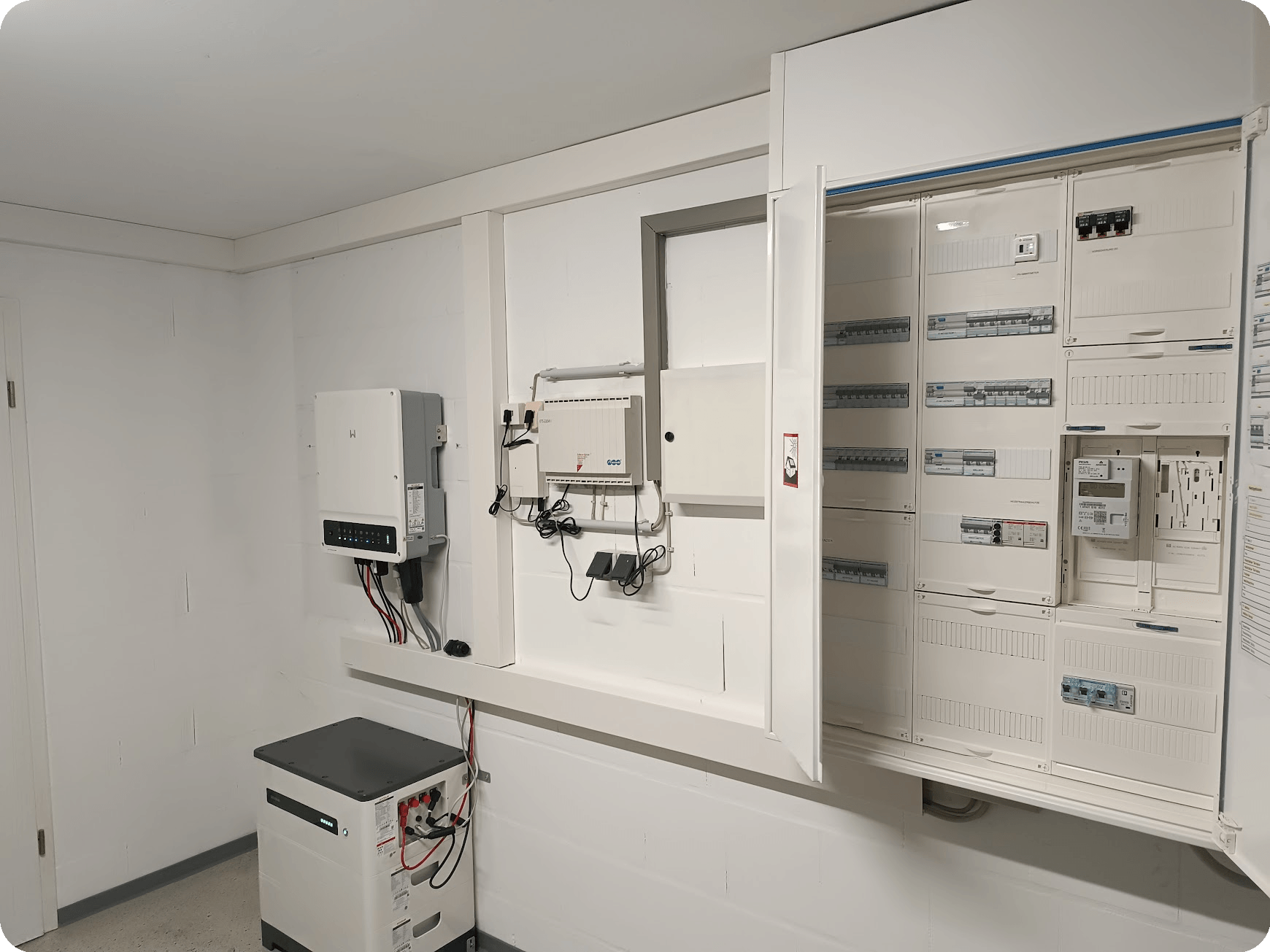Hager Z&auml;hlerschrank neben einem Photovoltaik Stromspeichersystem bestehend aus Hybridwechselrichter mit Notstromfunktion im Inselnetzbetreib und Stromspeicher
